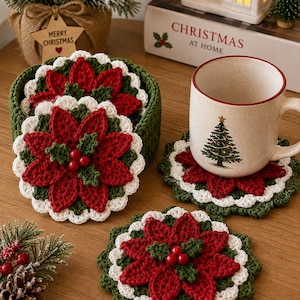 Puede incluir: Un juego de posavasos redondos de ganchillo con un diseño de flor de pascua roja, hojas verdes y un borde festoneado blanco. Los posavasos están apilados en un soporte de ganchillo verde a juego, con uno colocado bajo una taza de cerámica.