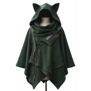 May include: A dark green hooded cape featuring two pointed cat-like ears on the hood. The garment includes a dark brown leather-like panel with black lace-up detailing on the front and two dark brown buckled straps across the upper chest area.