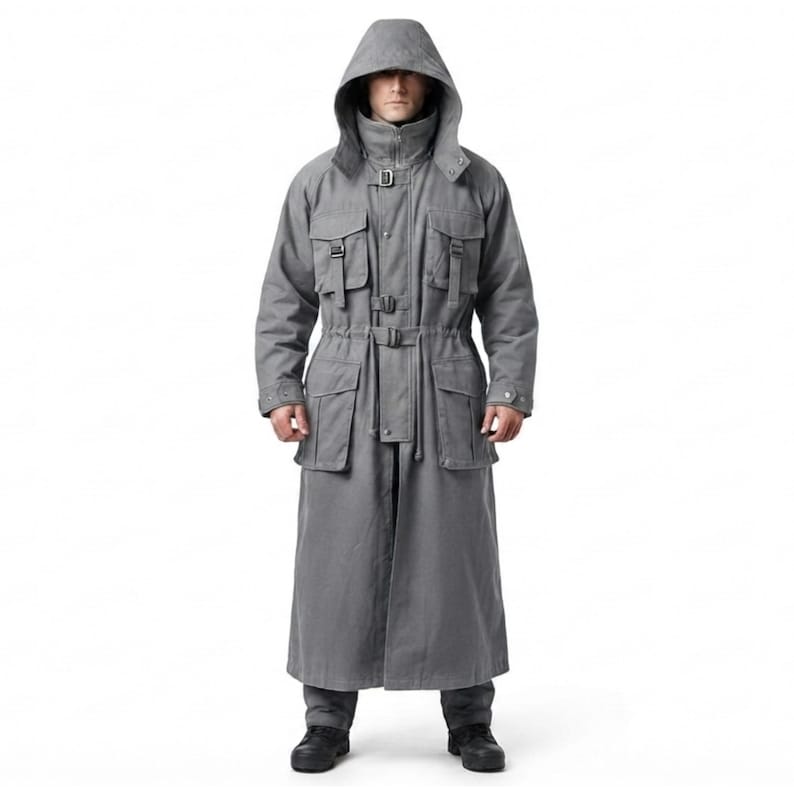 Peut inclure: Un long manteau gris &agrave; capuche dot&eacute; d'un col montant, d'une fermeture &eacute;clair frontale et de multiples poches utilitaires sur la poitrine et la taille. Le v&ecirc;tement comprend des sangles &agrave; boucle r&eacute;glables, des manches longues et un ourlet long.