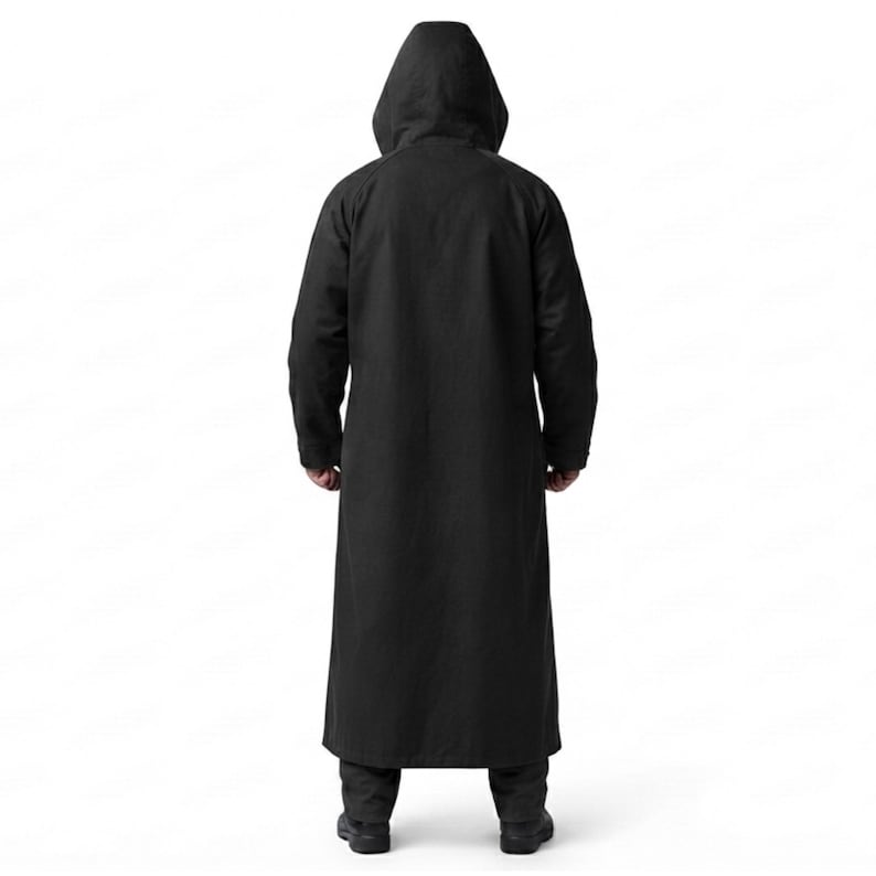 Peut inclure: Un long manteau noir uni &agrave; capuche, dot&eacute; d'une coupe longue descendant jusqu'au bas des jambes. Le v&ecirc;tement pr&eacute;sente des manches longues et une capuche, vu de dos, mettant en &eacute;vidence une conception en tissu noir uniforme et sans motif.
