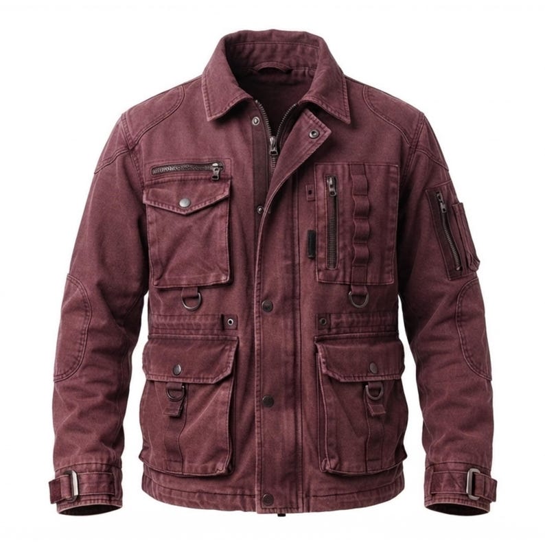 May include: A maroon utility jacket featuring a collared neckline, a full-length front zipper with a snap-button placket, multiple chest and waist pockets with flaps, vertical zippered pockets, D-ring attachments, and adjustable buckled cuffs.