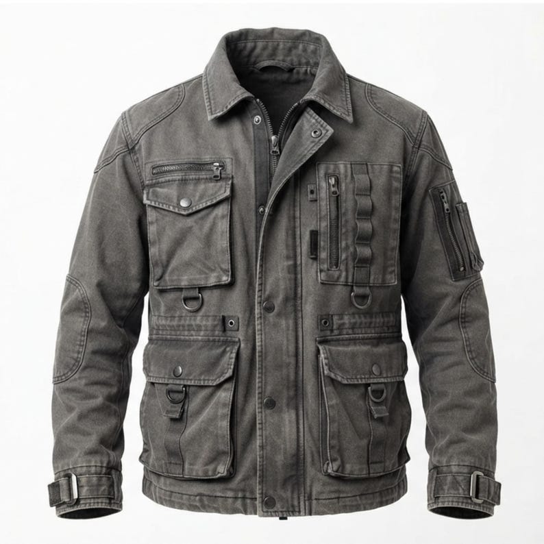 May include: A charcoal gray utility jacket featuring a fold-down collar, a front zipper closure with a snap-button placket, multiple chest and waist pockets with flaps, vertical zippered compartments, D-ring attachments, and adjustable sleeve cuffs.