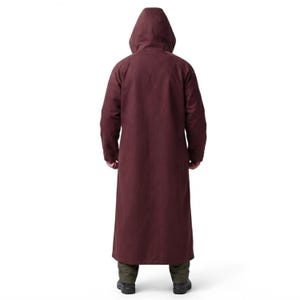 Peut inclure: Un long manteau &agrave; capuche de couleur bordeaux fonc&eacute; avec des manches longues, descendant jusqu'au bas des jambes. Le v&ecirc;tement pr&eacute;sente une capuche structur&eacute;e et un dos uni, port&eacute; sur un pantalon vert olive fonc&eacute; et des chaussures sombres.