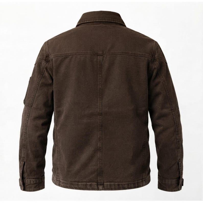 May include: A dark brown jacket shown from the back, featuring a classic collar, long sleeves with buttoned cuffs, and a vertical seam running down the center of the back panel. The garment has visible topstitching details throughout the construction.