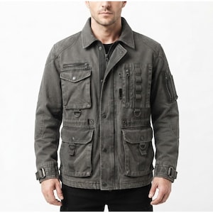 May include: A charcoal gray utility jacket featuring a fold-down collar, a front zipper closure with a snap-button placket, multiple chest and waist pockets with flaps, vertical zippered compartments, D-ring attachments, and adjustable sleeve cuffs.