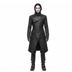 May include: A black long coat featuring a high collar with a buckle strap, a front closure with four horizontal buckle straps, two large flap pockets, and long sleeves with buckled cuffs. The coat is paired with matching black trousers and boots.