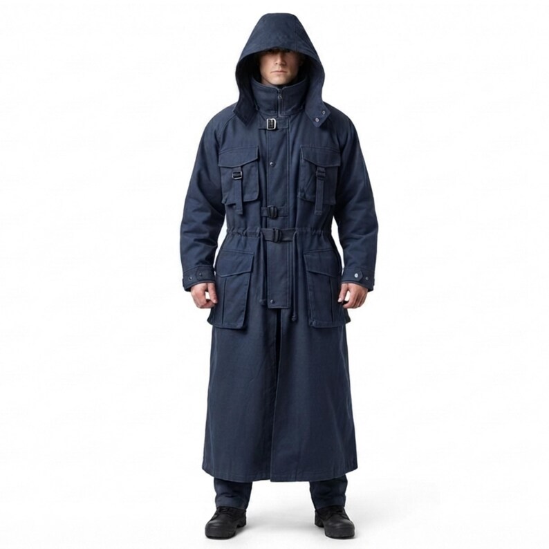 Peut inclure: Un long manteau &agrave; capuche bleu marine fonc&eacute; dot&eacute; d'un col montant, d'une fermeture &eacute;clair frontale et de multiples poches utilitaires sur la poitrine et la taille. Le v&ecirc;tement comprend des sangles &agrave; boucle r&eacute;glables au cou et &agrave; la taille.