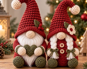 May include: Two crocheted gnomes with red pointed hats topped with cream pom-poms. The left gnome has a white beard and holds a green heart. The right gnome features white braided hair, two wooden heart buttons, and a small white flower on the hat.