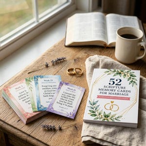 Può includere: Un set di 52 carte di memoria delle scritture per il matrimonio con una scatola bianca decorata con foglie verdi, linee geometriche dorate e due anelli dorati. Le carte includono testi come Week 3, Week 25 e Week 41 con versetti biblici.