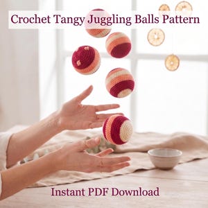 May include: Crochet Tangy Juggling Balls Pattern. Five spherical juggling balls featuring horizontal stripes in shades of cream, peach, orange, and deep magenta. The balls are suspended in mid-air, showcasing a textured yarn construction. Instant PDF Download.