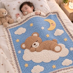 Puede incluir: Una manta de ganchillo para bebé en color azul claro con un oso marrón grande durmiendo sobre una nube blanca. La manta está decorada con una luna creciente amarilla, varias estrellas amarillas pequeñas y nubes blancas, con un borde festoneado.