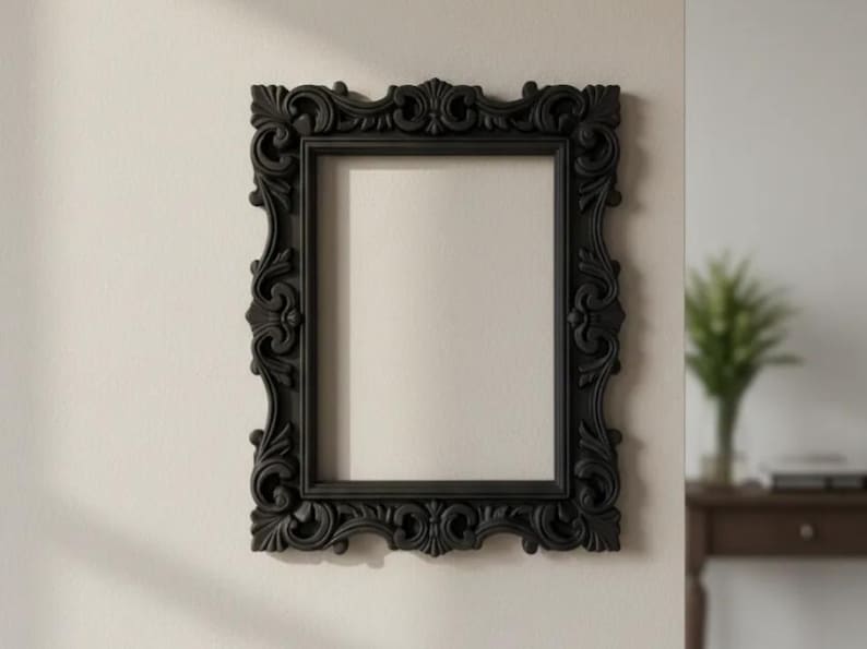 May include: A rectangular wall-mounted picture frame with a matte black finish. The frame features an ornate, raised relief border with intricate scrollwork, floral motifs, and symmetrical carvings along all four sides of the structure.