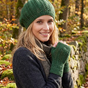 Könnte beinhalten: Eine dunkelgrüne Strickbarette und passende fingerlose Handschuhe mit einem vertikalen, blattartigen Strukturmuster. Die Barette hat einen gerippten Rand und die fingerlosen Handschuhe haben ein geripptes Bündchen aus tiefgrünem Garn.