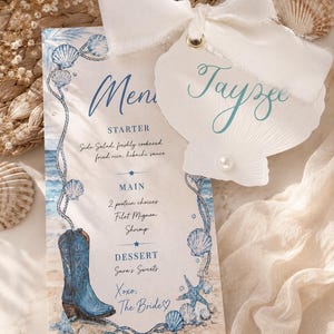 May include: A rectangular menu card featuring blue watercolor illustrations of seashells, a rope border, and a blue cowboy boot. A shell-shaped name tag with the name Tayzee and a white ribbon is attached. The text includes Menu, Starter, Main, and Dessert.