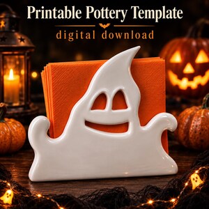 May include: A white ceramic ghost-shaped napkin holder containing orange napkins. The text at the top reads Printable Pottery Template and digital download. The ghost has cutouts for eyes and a mouth, with a smooth, glossy finish and curved edges.