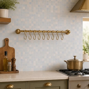 Peut inclure: Une barre de cuisine horizontale en laiton fixée au mur, dotée d'une tige cylindrique avec des embouts arrondis et dix crochets en forme de S en laiton assortis, conçue pour organiser et suspendre divers ustensiles de cuisine ou casseroles.