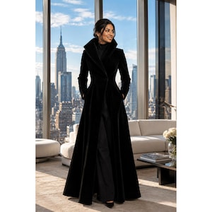 May include: A floor-length black coat featuring a high, structured collar and long sleeves. The garment is tailored with a fitted waist that flares into a full-length skirt, providing a sleek silhouette. The coat is made of a solid black fabric.