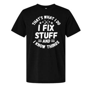 May include: Black t-shirt with white text that reads "THAT'S WHAT I DO I FIX STUFF AND I KNOW THINGS." The design includes a wrench and screwdriver graphic. The shirt is a crew neck style.