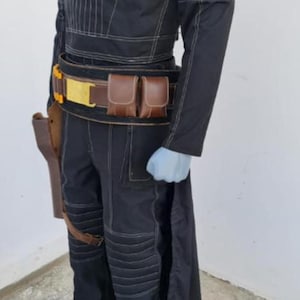 May include: A black long-sleeved tunic and matching trousers featuring white topstitching, a high collar, and a dark brown utility belt with two pouches and a gold buckle. A brown holster is attached to the belt, and the outfit includes a long back panel.