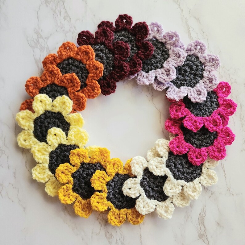 All the sunflower car coaster color options spread out into a circle. Colors shown are burgundy red, light purple, magenta pink, cream, mustard yellow, light yellow and orange.