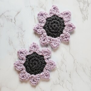 Light purple crochet sunflower coasters.