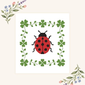 Può includere: Una tela digitale per ricamo a mezzo punto raffigurante una coccinella rossa con punti neri centrata all'interno di una cornice quadrata di trifogli verdi a quattro foglie. Il testo Digital Needlepoint Canvas appare in alto, con rametti floreali agli angoli.
