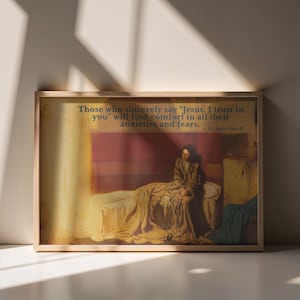 May include: A framed horizontal print featuring a painting of a person sitting on a bed draped in yellow fabric. The text reads: Those who sincerely say "Jesus, I trust in you" will find comfort in all their anxieties and fears. — St. John Paul II.