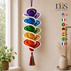 May include: A hanging crochet spiral decoration featuring a vertical sequence of spheres in rainbow colors, including purple, blue, green, yellow, orange, and red. Each sphere is surrounded by a white-edged spiral, ending in a multi-colored tassel.