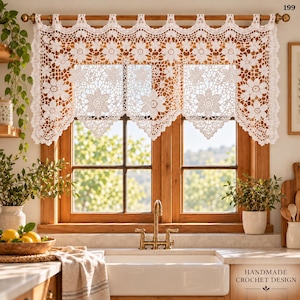 May include: A white crochet valance curtain featuring a repeating floral pattern with scalloped edges, suspended from a wooden rod. The intricate lace design displays detailed flower motifs and openwork, covering the top portion of a window.