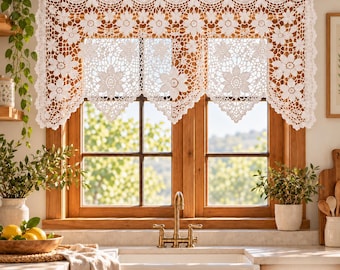 Puede incluir: Una cenefa de cortina de ganchillo blanco con un patrón floral repetitivo y bordes festoneados, colgada de una barra de madera. El intrincado diseño de encaje muestra motivos florales detallados y calados sobre la ventana.