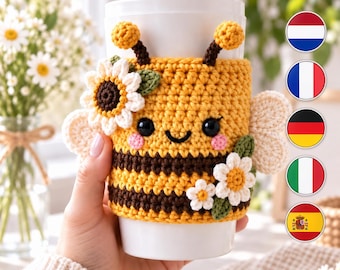 Puede incluir: Una taza de viaje blanca con una funda de ganchillo hecha a mano con diseño de abeja, rayas amarillas y marrones, ojos de cuentas negras, mejillas rosas, dos antenas, alas color crema y flores de margarita blancas con hojas verdes.