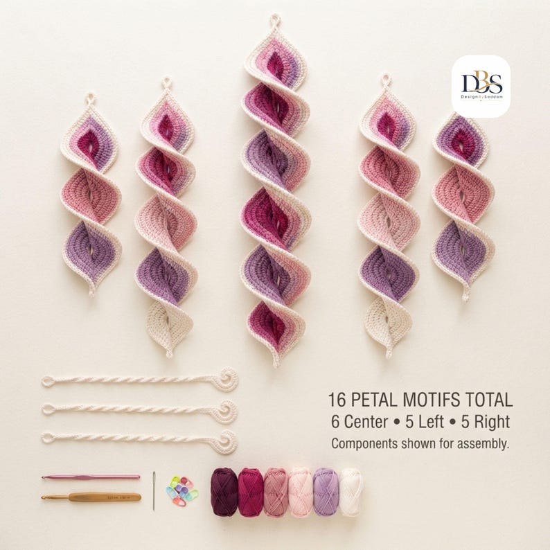 May include: A crochet kit featuring five spiral petal motifs in shades of pink, purple, and cream. Includes three twisted cords, two crochet hooks, a needle, stitch markers, and six yarn skeins. Text reads: 16 PETAL MOTIFS TOTAL 6 Center 5 Left 5 Right.