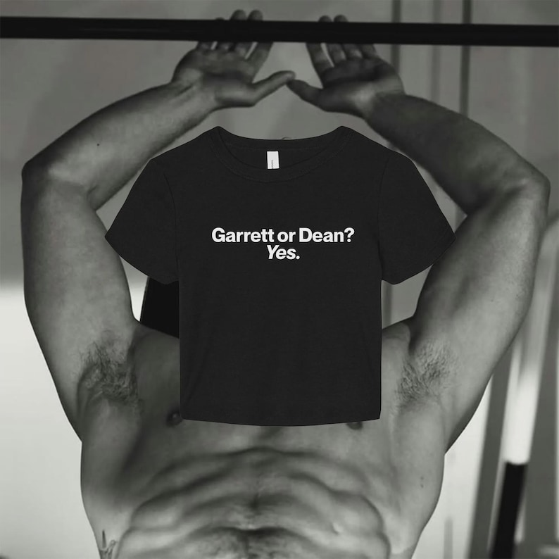 May include: A black short-sleeved crew neck t-shirt featuring the white printed text "Garrett or Dean? Yes." centered on the chest. The garment has a standard fit with a round neckline and short sleeves, presented in a clear, straightforward design.