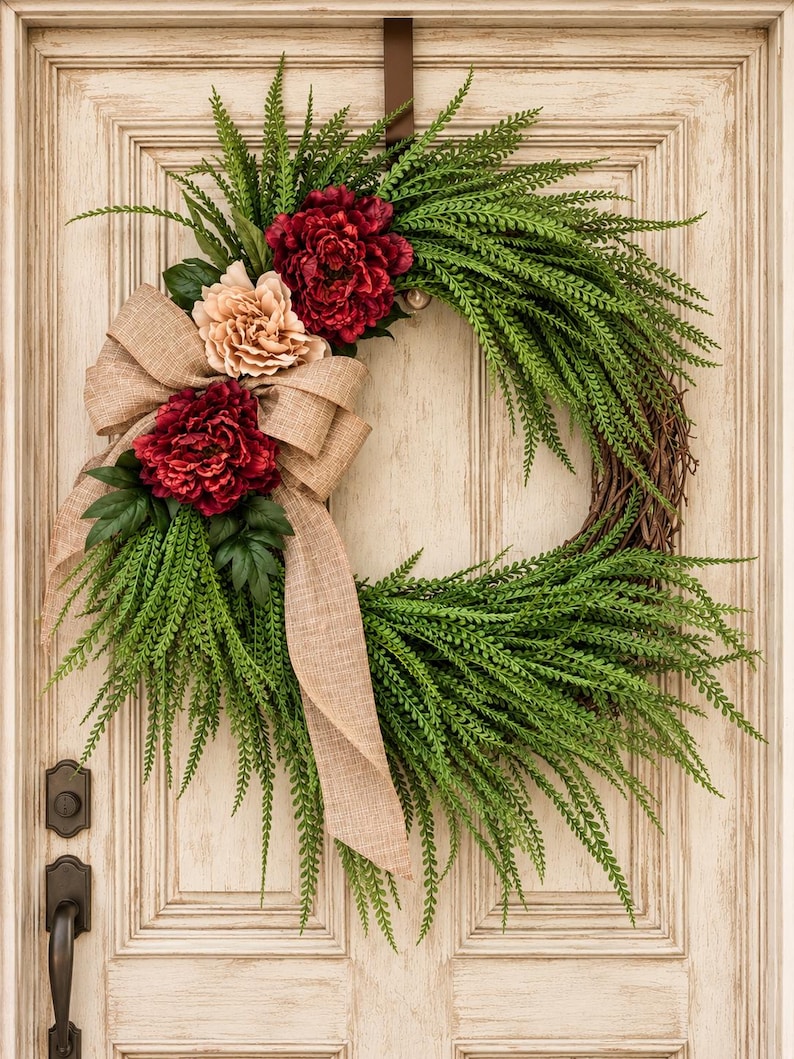 Evergreen winter wreath with cedar, red and cream peonies and a burlap bow