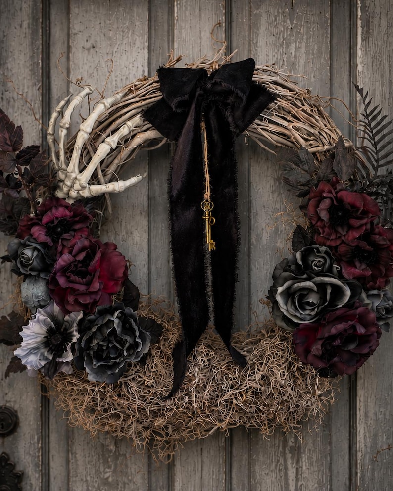 Gothic Halloween wreath with burgundy and black roses, a skeleton hand and a vintage key