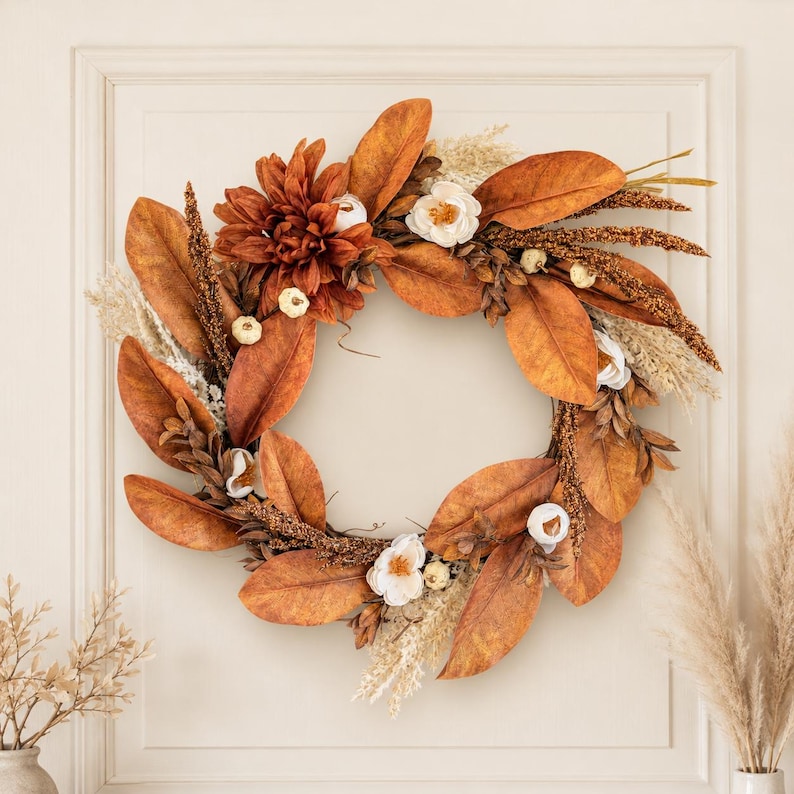 Neutral boho fall wreath with copper magnolia leaves, cream blooms and white pumpkins