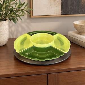 May include: A multi-section serving tray featuring a central round lime green bowl surrounded by four distinct wedge-shaped ceramic dishes in alternating shades of lime green and dark forest green, all arranged on a circular dark gray base.