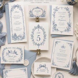 Pu&ograve; includere: Un set di cancelleria per matrimoni con illustrazioni floreali e di uccelli in stile chinoiserie blu e bianco. Il set include un menu, un numero da tavolo, un save the date, un biglietto di ringraziamento e segnaposti con del testo.