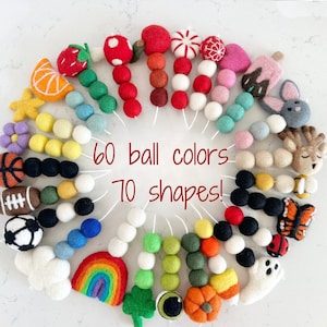 May include: A colorful garland of felt balls and shapes, including a rainbow, a pumpkin, a ghost, a butterfly, a deer, a basketball, a football, a soccer ball, a cloud, a strawberry, a flower, a star, a candy cane, a heart, an orange slice, a shamrock, and a ladybug. The garland is made of 60 different colors and 70 different shapes.