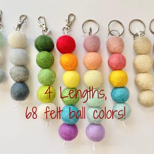 May include: Seven colorful felt ball keychains with silver key rings. Each keychain has four felt balls in different colors. The text "4 Lengths, 68 felt ball colors!" is printed below the keychains.
