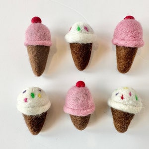 Pode incluir: Seis cones de gelado de feltro, tr&ecirc;s com gelado rosa e tr&ecirc;s com gelado branco. Os cones de gelado t&ecirc;m granulado e uma cereja vermelha no topo.