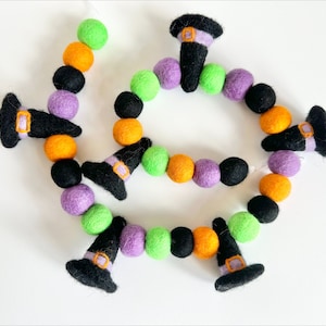 May include: A Halloween garland with black felt witch hats, orange, green, and purple felt balls.