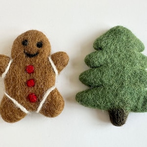 May include: A brown gingerbread man with white icing and red buttons, and a green felt Christmas tree.