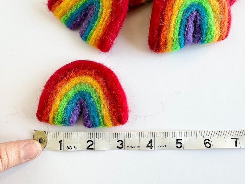 May include: A rainbow-coloured felt rainbow measuring 5 cm wide. The rainbow is made of felt and is a bright, cheerful colour.