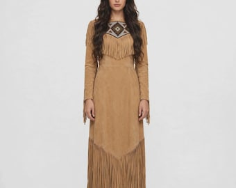 Vestido feminino estilo country com franjas, modelo boho em tons de bege, ideal para powwows e festivais com inspiração indígena.