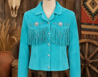 May include: A bright turquoise suede jacket featuring a classic collar, long sleeves, and a front button closure. The chest area is adorned with silver-toned concho accents, intricate beadwork, and long, flowing fringe detailing across the front.