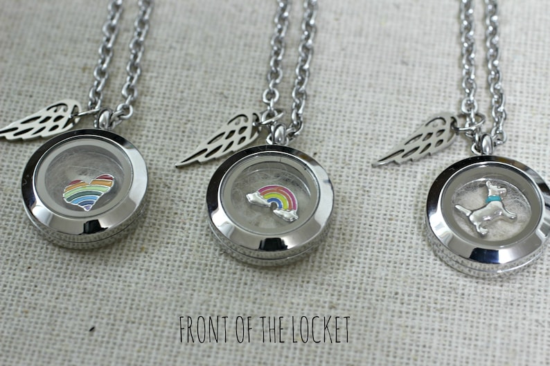 May include: Three silver locket necklaces with angel wing charms. The lockets feature a rainbow heart, a rainbow, and a small dog.