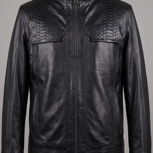 Peut inclure: Une veste noire combinant du cuir lisse et des panneaux texturés à motif peau de serpent. Le vêtement présente une fermeture éclair frontale intégrale, un col montant et deux poches de poitrine, offrant une coupe structurée avec des détails verticaux.