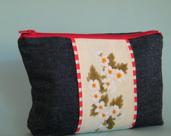 Durable denim make up pouch with hand embroidered flowers.