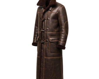 May include: A long, dark brown distressed leather coat featuring a thick, dark brown shearling lining and a large fold-over collar. The coat includes three toggle closures down the front, two large rectangular patch pockets, and elbow patches.